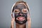Happy Woman Using Activated Charcoal Face Mask