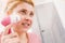 Happy woman using facial cleansing brush