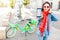 Happy woman using smart phone and rent mobile application to share modern green electric bicycle, alternative eco