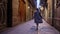 Happy woman walking alone in Barcelona Gothic Quarter. Old apartment buildings, narrow streets of Europe. Traveling in