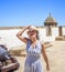 A happy woman walking along an antique Latinamerican marina promenade