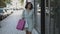 Happy woman walking along street with shopping bags