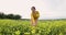 Happy woman walking in a field with yellow flowers. Beautiful carefree woman enjoying nature in blooming field