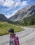 Happy woman walking and smile on a mountain road in active trekking lifestyle activity - summer vacation in outdoor park - people