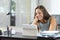 Happy woman watching tablet media on a desk at home