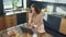 Happy woman watching video in kitchen. Smiling female person looking at computer