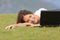 Happy woman watching videos in a laptop lying on the grass
