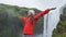 Happy woman by waterfall Skogafoss on Iceland