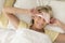 Happy Woman Wearing Sleep Mask On Bed