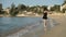 Happy woman in wet dress fooling around on the beach