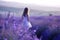 A happy woman in a white dress standing in a lavender field