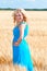 Happy womanin blue dress in golden wheat