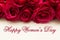 Happy Womans Day March 8th written on white card with red roses