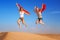 Happy women jumping in the desert