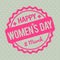 Happy Women`s Day rubber stamp baby pink on a Retro grey background.