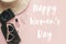 Happy Women`s Day text sign at stylish girly photo camera, retro sunglasses, jewelry, hat on pastel pink paper. Girl Power.