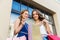 Happy women with shopping bags at storefront