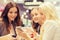 Happy women with smartphones and tablet pc in mall