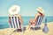 Happy women sunbathing in lounges on beach