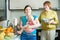 Happy women of three generations cooking fruit puree