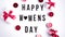 Happy womens day text on white table background, with gift boxes and candles