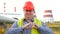 Happy worker, engineer, or electrician looking at the camera and showing love gesture in front of a power station