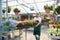 Happy worker growing flowers in a greenhouse of a flower shop