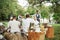 Happy workers. Waiters serve group of good friends that sit outdoors on the beautiful field with trees