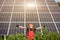 Happy working solar station raising his hands on a background of photovoltaic panels