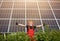 Happy working solar station raising his hands on a background of photovoltaic panels