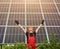 Happy working solar station raising his hands on a background of photovoltaic panels