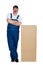 Happy workman standing by large cardboard box