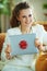 Happy young 40 years old woman showing gift laptop with red bow
