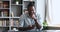 Happy young adult African man using smartphone in home office