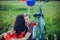 Happy young adult couple in love on the field. Two, man and woman have picnic, smiling and resting on the green grass.