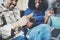 Happy young african american couple sitting on sofa at home and shopping online through mobile computer by credit card