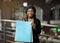 Happy young african american lady shows colored paper bags with purchases