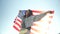 Happy young African American woman holding usa flag dancing at sky background.