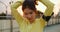 Happy young Asia athlete lady in yellow clothes preparing for training in urban environment. Korean teen girl tying in ponytail