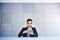 Happy Young Asian Businessman Working on Smartphone. Smiling and Sitting at the Desk in Industrial Loft Office