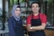 Happy young asian couple cafe owner in front of coffee shop smiling. portrait of two waiters at restaurant