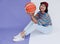 Happy young asian girl palying basketball with pastel background