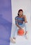 Happy young asian girl palying basketball with pastel background