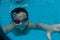 Happy young asian kid with swim goggles underwater