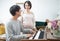 Happy young asian pregnant woman stand side of man play piano at home. Pregnancy, motherhood, people, love, expectation, family -