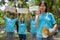 Happy young Asian students diverse volunteers hold a campaign sign for cleaning in the park, The concept of environmental