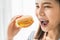 Happy young Asian woman holding burger for eat.