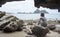 Happy young asian woman sitting on a rock front of cave near the sea,looked to the left,chill out of summer,happy time