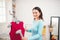 Happy young asian woman steaming clothes in room