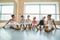 Happy young ballerinas sitting on the floor.